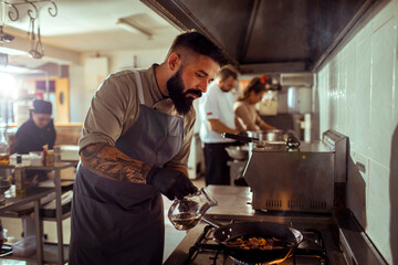 Chef cooking in professional kitchen with focus and concentration