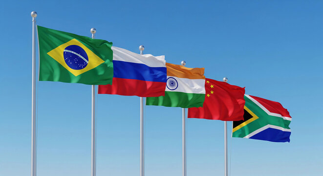 Flags of BRICS nations&mdash;Brazil, Russia, India, China, and South Africa&mdash;are shown waving together under a clear blue sky, symbolizing unity, cooperation, and emerging global economic power