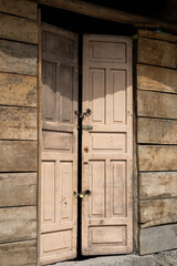 A beautifully aged wooden door stands at the entrance of an old house, rich with texture and character. The rustic design reflects history, craftsmanship, and timeless simplicity.

