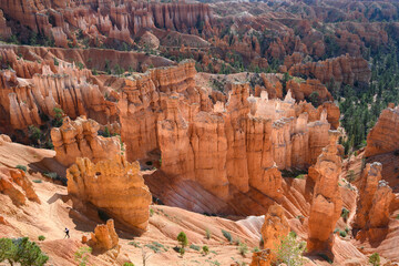 View from canyon rim of rock hoodoos and people on the queens loop hiking trail, summer vacation exploring in Bryce Canyon National Park, Utah
