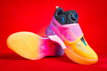 pair of pink and orange sporty shoes for kid on red background