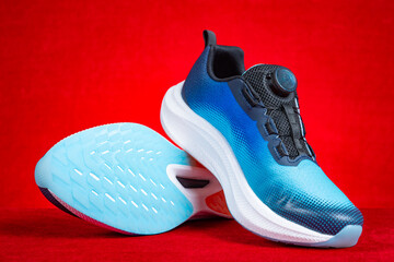 pair of blue sporty shoes for kid on red background