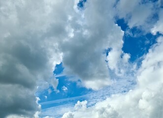 White and gray clouds drifting across a vibrant blue sky
