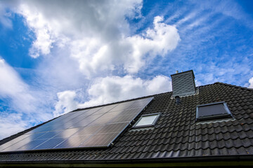 Photovoltaic panels providing green energy on a roof under cloudy sky