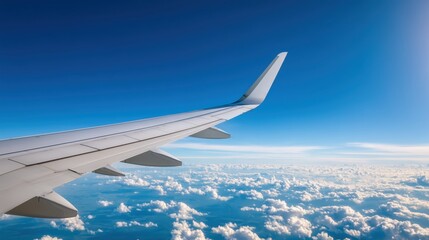 Obraz premium close-up of an airplane wing in mid-flight, clear blue sky,