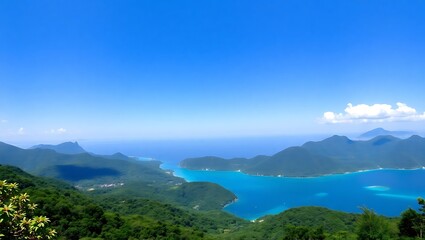 "Panoramic View of Lush Forested Mountains Overlooking the Sea Under a Clear Blue Sky"