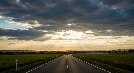 Sunbeams Through Clouds Over Winding Country Road at Sunset