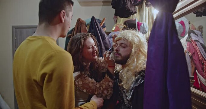 Actors prepare backstage, applying makeup and costumes in the dressing room, creating a theatrical atmosphere.