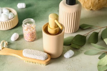 Bottles of cosmetic products, massage brush, sea salt and cotton balls on color background, closeup