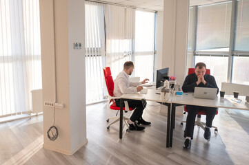 Two Caucasian men working in an office. 