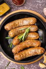Frying pan of tasty homemade sausages on grunge background