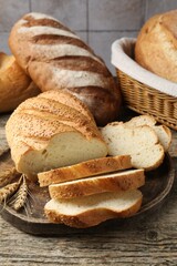 Cut bread loaf and spikes on wooden table, closeup