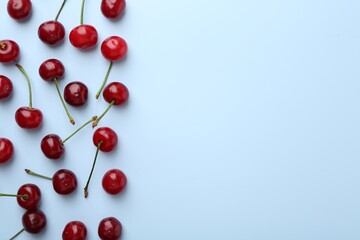 Fresh ripe cherries on light background, flat lay. Space for text