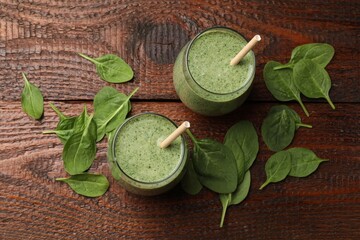 Tasty smoothie and spinach leaves on wooden, flat lay