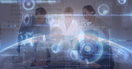Team in formal attire leaning over desk in meeting area, with laptop charts and holographic overlay