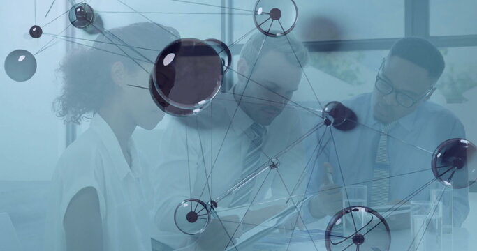 Collaborating team consulting paperwork and using tablet in conference room with network overlay