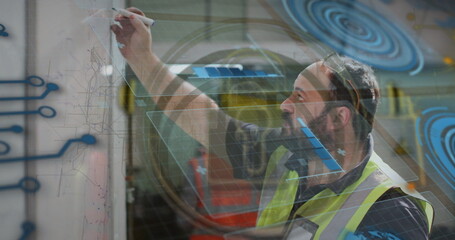 Engineer in safety vest drafting diagrams on panel in workshop, with hologram overlays, copy space