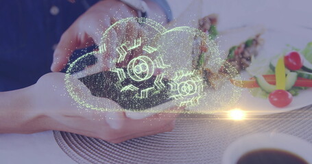 Holding smartphone projecting holographic cloud above dining table, with skewers and coffee cup