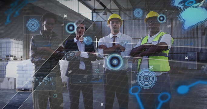Collaborating team wearing yellow hard hats and vest studying holograms around pallets in warehouse