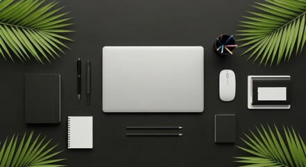 Flat lay of a laptop with office equipment and palm leaves on a dark table