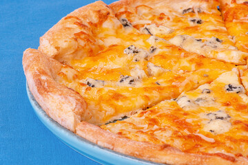 Cheese pizza on a blue plate. Four cheese pizza on a blue tablecloth.