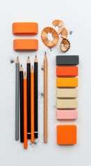 An overhead view of pencils, erasers, and shavings on a clean, white backdrop