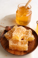Plate with sweet honeycombs on white background