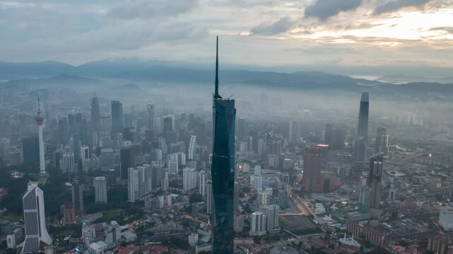 Aerial view time lapse 4k video of Kuala Lumpur city center view during dawn overlooking the city skyline in Federal Territory, Malaysia. Tilt up