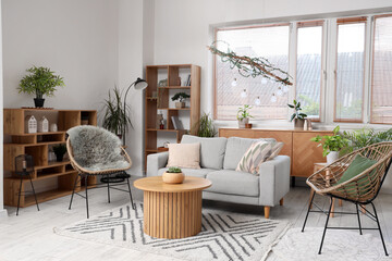 Interior of modern living room with comfortable sofa, armchairs and table