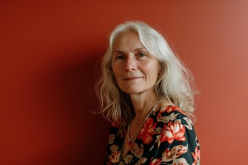 Portrait of a senior woman on a red background. The concept of pensioners and lifestyle.