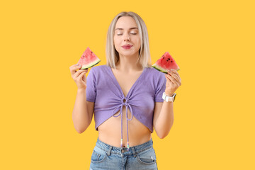 Beautiful young woman with slices of fresh watermelon on yellow background