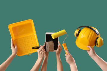 Women with painter's tools and tablet computer on green background