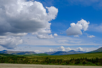 Road and green landscape with mountain on sunny day, panoramic view.