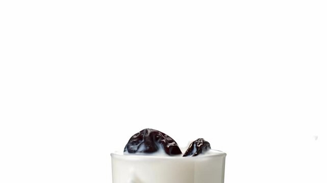 Yogurt with dairy pulm, prune in milk splash isolated on white background