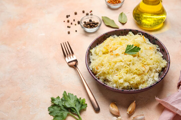 Bowl with delicious sauerkraut and different spices on pink background