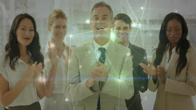 Corporate team clapping celebrating achievement fueling glowing network overlay pulsing in office - Powered by Adobe