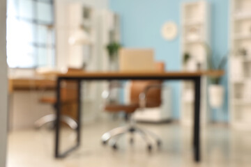 Blurred view of stylish office with workplaces and shelf units