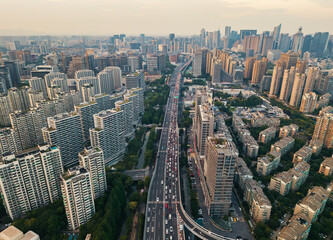 Aerial view of a busy highway surrounded by urban skyscrapers during sunset in a major city