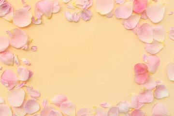 Frame made of pink rose petals on yellow background