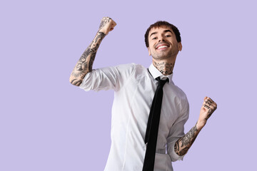 Happy young man in shirt on lilac background