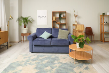 Interior of modern room with comfortable sofa, coffee table and houseplant