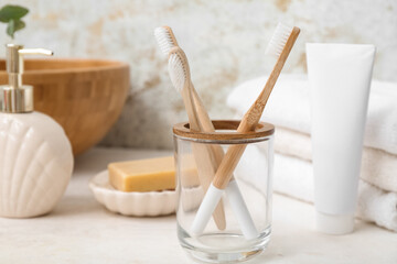 Holder with bamboo toothbrushes and bath supplies on light table