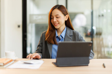 Portrait of Creative young woman working on tablet laptop in her office
