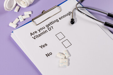 A paper with a health-related question regarding essential vitamins E, placed beside a stethoscope...
