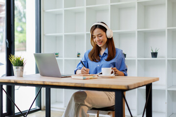 Smiling girl student wear headphone study online with teacher, happy asian woman learn language...
