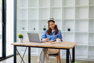 Smiling girl student wear headphone study online with teacher, happy asian woman learn language...