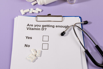 A paper with a health-related question regarding essential vitamins E, placed beside a stethoscope...