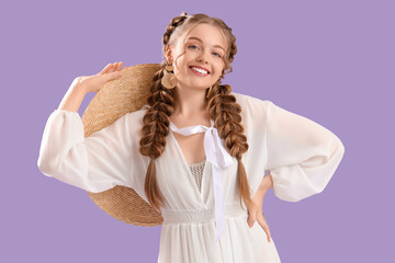 Happy smiling young woman with braids in dress on lilac background