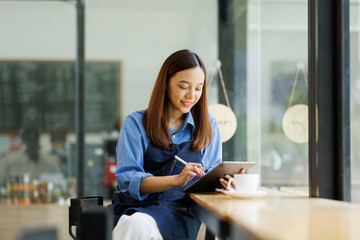 Asian woman, tablet and small business in ecommerce, fashion or logistics in remote startup at work. asian female owner working on touchscreen technology in clothing store success
