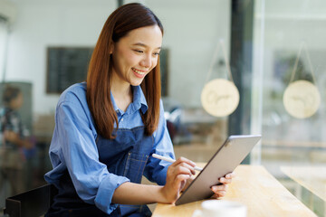 Asian woman, tablet and small business in ecommerce, fashion or logistics in remote startup at work. asian female owner working on touchscreen technology in clothing store success
